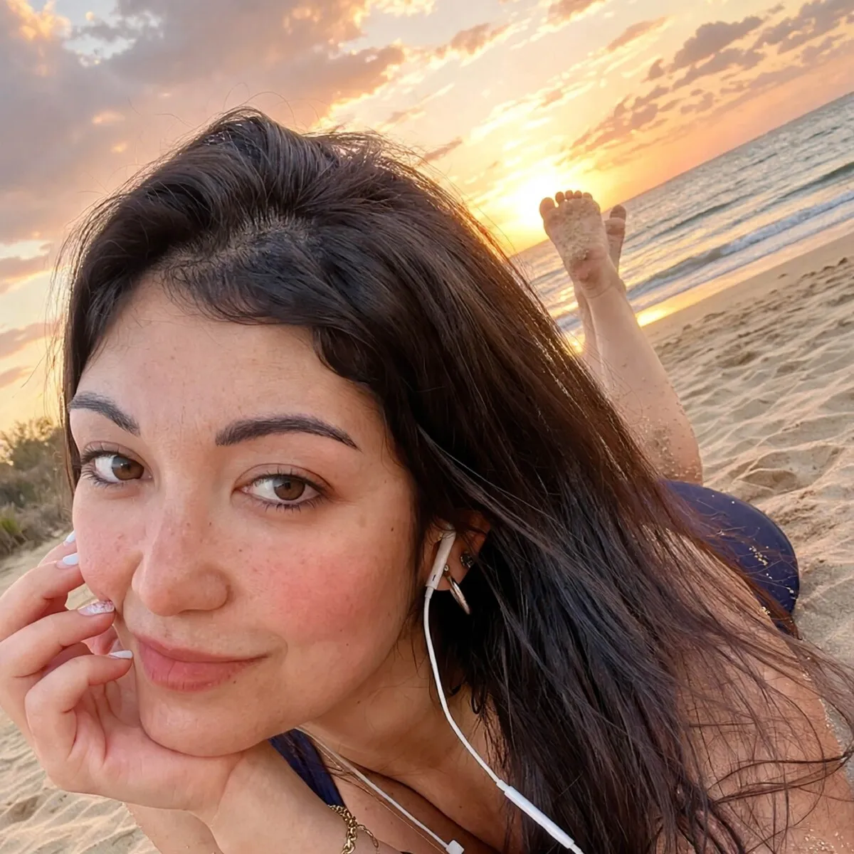 Oriana relajada sobre la arena al atardecer